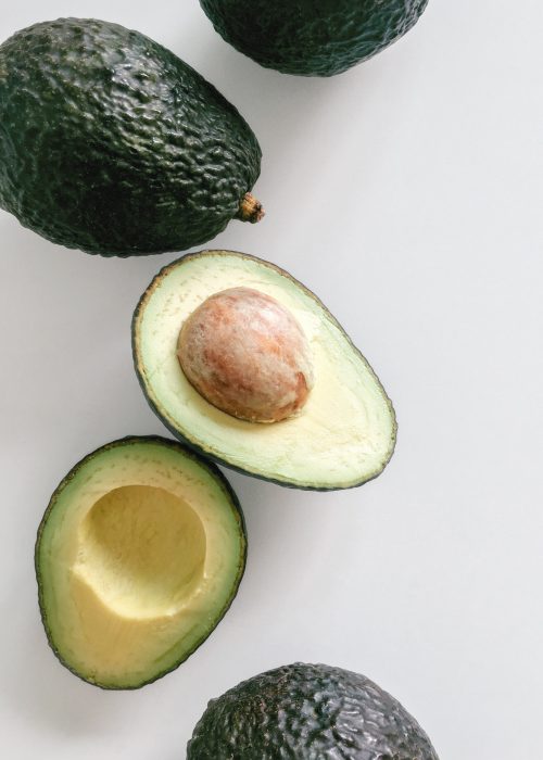 Fresh organic hass avocados on a white background, flat lay healthy food